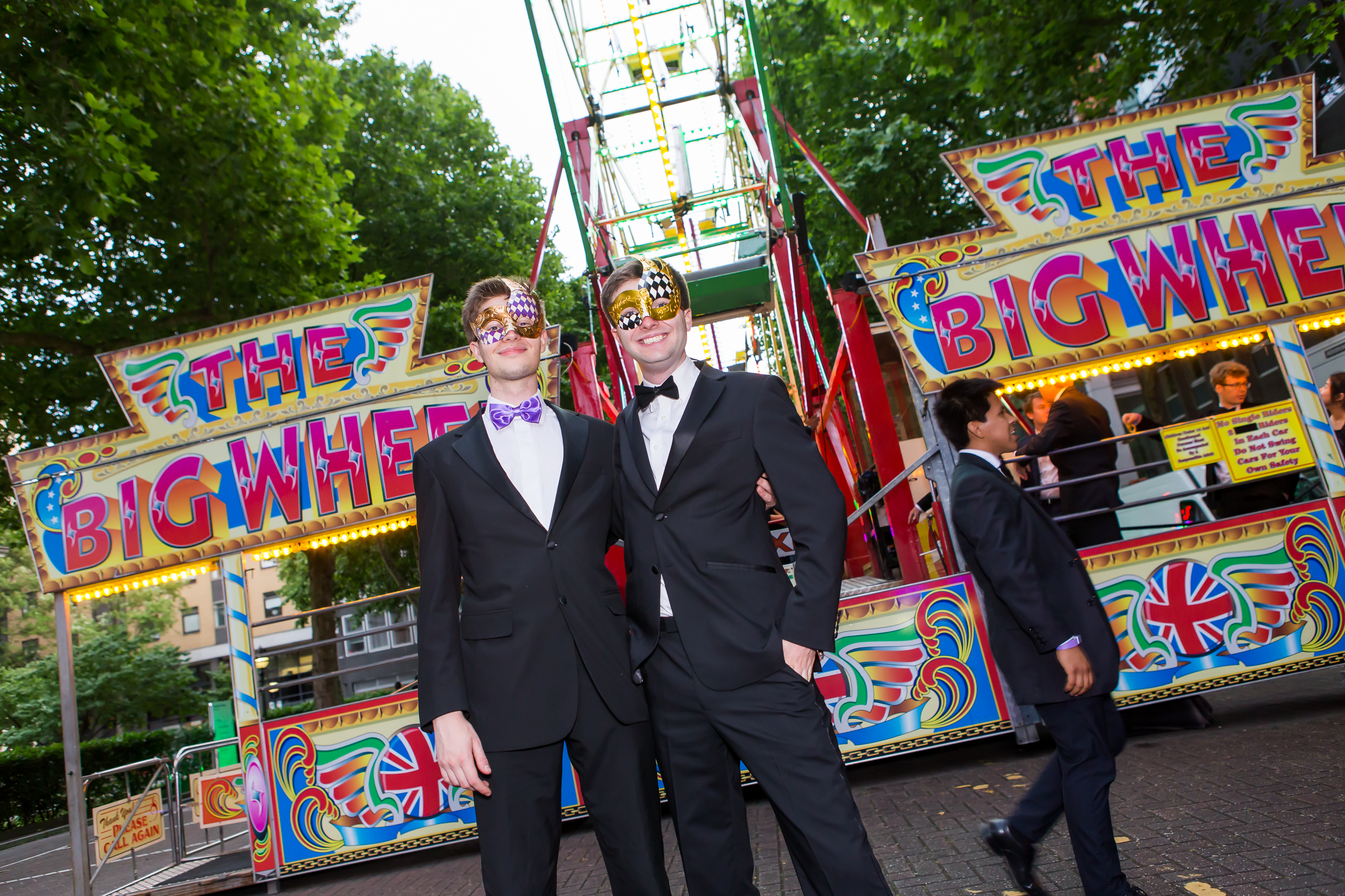 Two face-painted student posing in front of the big wheel fairground ride,