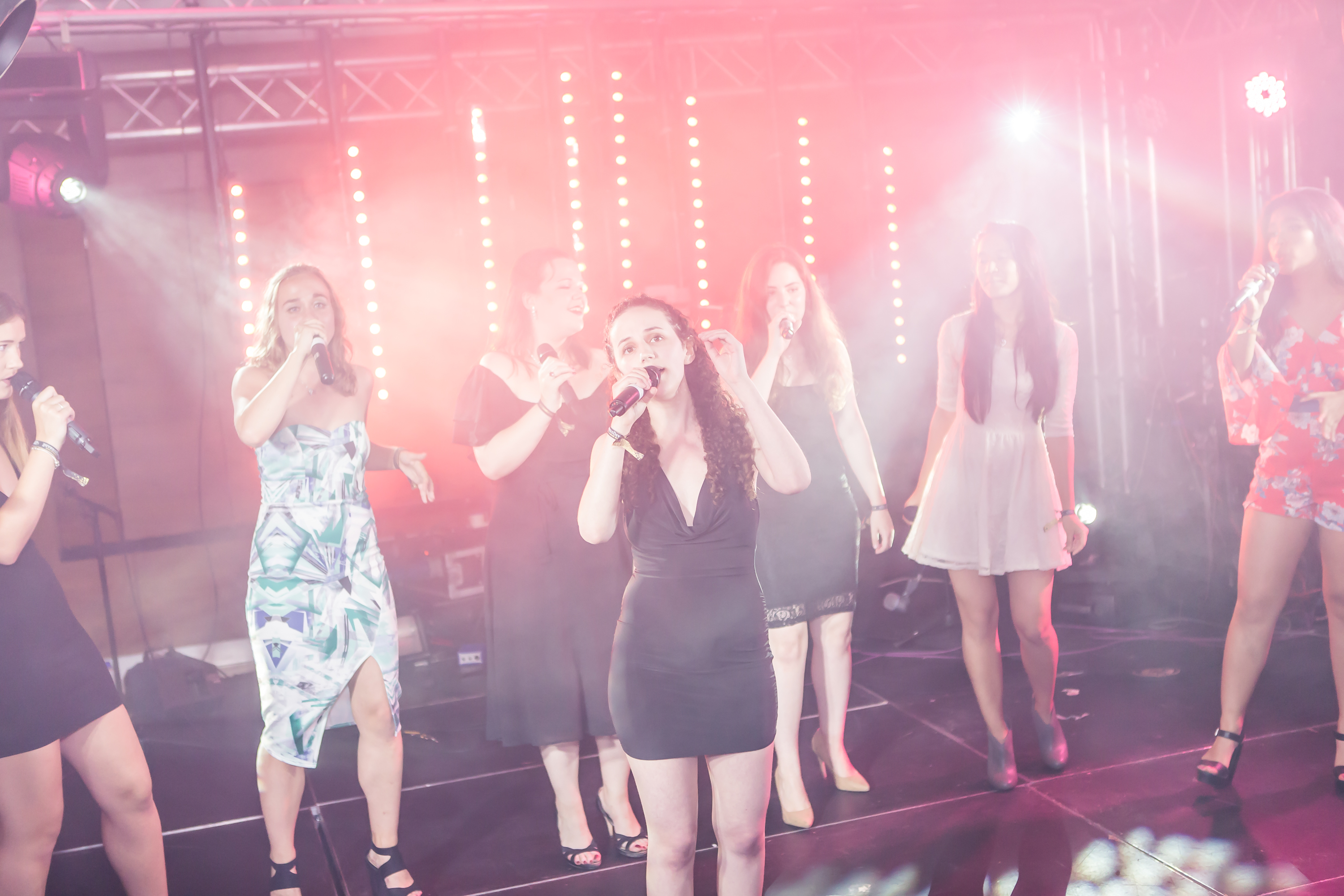 A cappella group under bright stage lights.