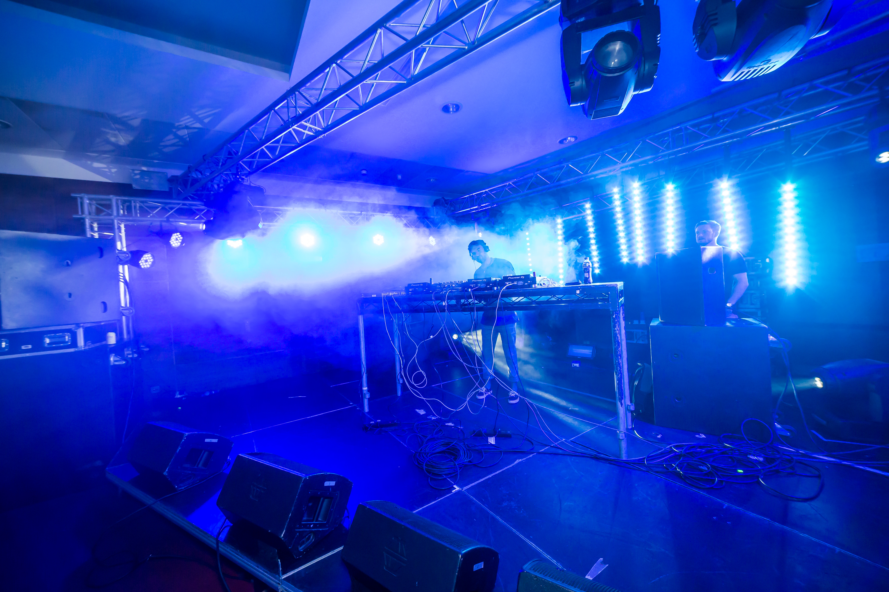 DJs on stage lit up in blue.